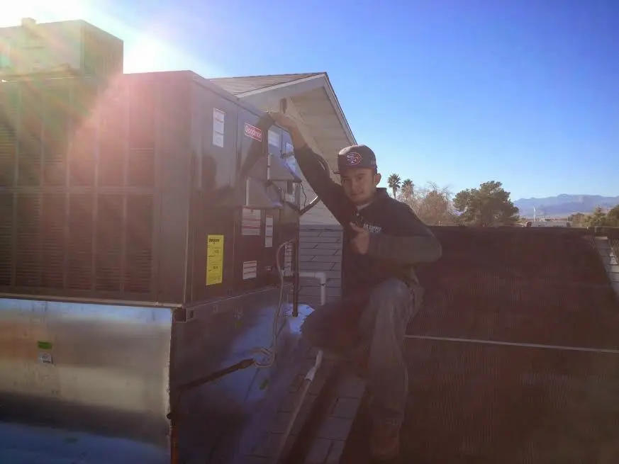 HVAC technician performing AC Tune-Up on a rooftop unit in Sierra Madre